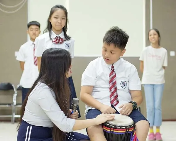 博纳学校音乐课堂中教师指导学生练习手鼓